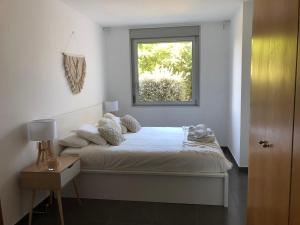 um quarto branco com uma cama e uma janela em Standing Apartment Barcelona Forum em Barcelona