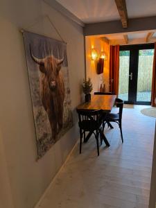 uma sala de jantar com uma pintura de um touro na parede em B&B Stoet & Berre Geheel privé 1 - 4 pers em Assen