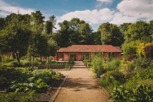 einen Garten mit einem Haus im Hintergrund in der Unterkunft Hampton Manor in Hampton in Arden