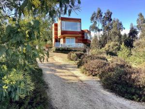 una casa en una colina con un camino de tierra en Agradable casa de campo 2 pisos con piscina. en Algarrobo
