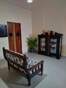 a living room with a bench and a cabinet at Pousada Caminhos da Chapada in Palmeiras