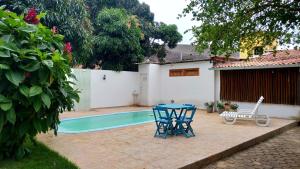 a patio with a table and two chairs next to a pool at Pousada Caminhos da Chapada in Palmeiras