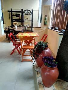 uma sala de jantar com uma mesa e duas cadeiras vermelhas em Pousada Caminhos da Chapada em Palmeiras