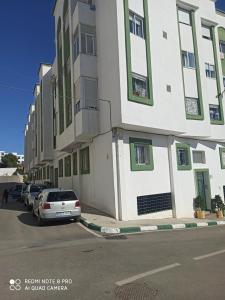 a white building with cars parked next to a street at The Oxygen 7 in Tetouan