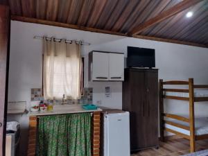 una cucina con un frigorifero bianco e un lavello di Chalés Cachoeira do Cafundó a Bueno Brandão