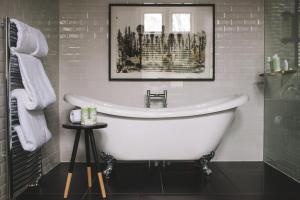 a white bath tub in a bathroom with a picture at Hampton Manor in Hampton in Arden +64 photos