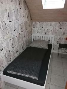 Cama en habitación con pared de piedra en Ferienhaus Stein Haselweg, en Öhringen