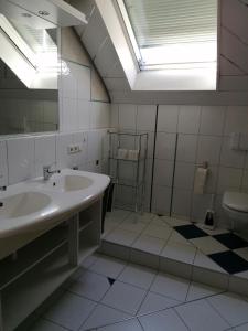 a bathroom with a sink and a mirror and a toilet at Ferienhaus Stein Haselweg in Öhringen