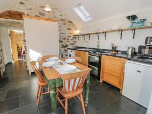 a kitchen with a table and chairs in a room at Cwch Gwenyn in Holyhead