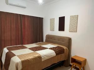 - une chambre avec un lit et deux photos sur le mur dans l'établissement Condomínio San Victor, à Bombinhas
