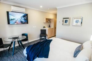 a hotel room with a bed and a table at Warners at the Bay in Warners Bay