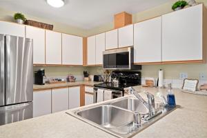 a kitchen with white cabinets and a stainless steel sink at Walk to Downtown Festivities 2Bd2Ba Condo in Leavenworth