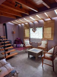 sala de estar con sillas, mesa y escaleras en Terrazas de Ruca Hue en San Martín de los Andes