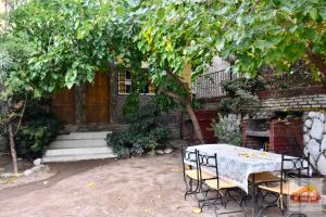 einen Tisch und Stühle unter einem Baum im Hof in der Unterkunft Cabañas El Challao in Mendoza