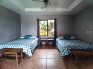 2 camas en una habitación con ventana en Regenerate Wellness Center at Villas Escondidas, en Grecia