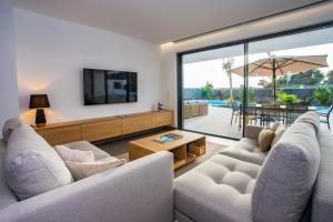 a living room with two couches and a tv at Villa Macán in Teguise