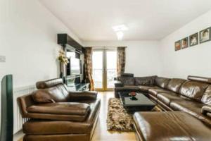 a living room with a leather couch and a table at Luxury 2 bedroom apartment in Central London with free Parking in London