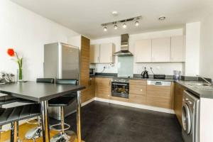 a kitchen with white cabinets and stainless steel appliances at Luxury 2 bedroom apartment in Central London with free Parking in London