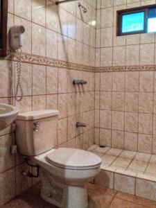 y baño con aseo y lavamanos. en Regenerate Wellness Center at Villas Escondidas, en Grecia