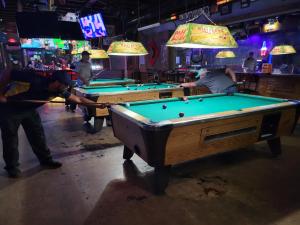 a group of men playing pool in a bar at Bayou Chateau and Chateau Royale in New Iberia