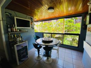 una pequeña cocina con mesa y ventana en Apartamento Atlantico, en Matinhos