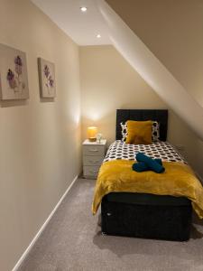 a bedroom with a bed with a yellow comforter at Harrietsham House in Kent
