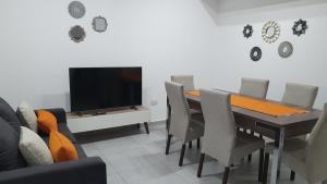 Apartamento Deluxe Senderos del Vino IV, Desayuno Opcional في ميندوزا: غرفة طعام مع طاولة مع كراسي وتلفزيون