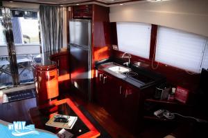 uma pequena cozinha com pia e geladeira em Barco no Coração da Cidade - Iate de 5 estrelas em Viana do Castelo