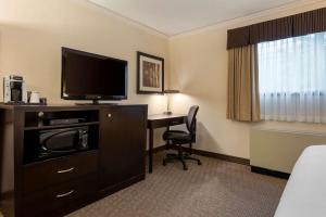 a hotel room with a desk and a television at Best Western Plus Baker Street Inn & Convention Center in Nelson