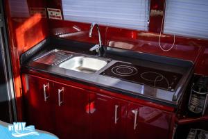 uma pequena cozinha com pia e fogão em Barco no Coração da Cidade - Iate de 5 estrelas em Viana do Castelo