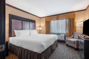 a hotel room with a large bed and a chair at Best Western Plus Fernie Mountain Lodge in Fernie