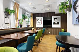 um restaurante com mesas e cadeiras e uma televisão em Best Western The Public Hotel em Akersberga
