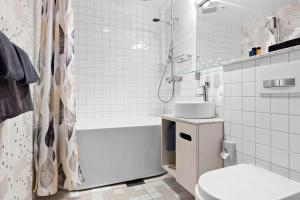 a white bathroom with a sink and a toilet at Best Western The Public Hotel in Åkersberga