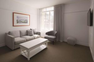 a living room with a couch and a chair at Adina Apartment Hotel Brisbane Anzac Square in Brisbane