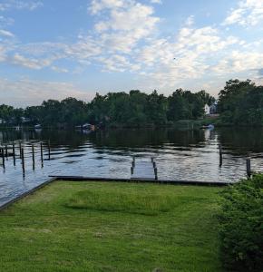 a large body of water with a dock in the grass at A cozy house on a waterfront property in Baltimore