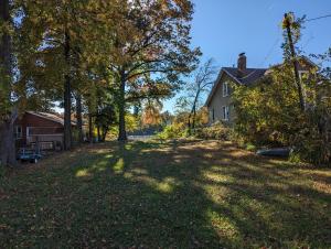 an empty yard with a house and trees at A cozy house on a waterfront property in Baltimore