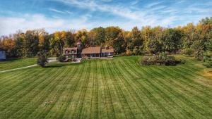 an aerial view of a large house in a field at Hillside Estate - 14 Acre Waterfront Log home on Lake Champlain in Grand Isle