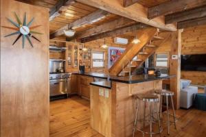 una cocina con armarios de madera y un reloj grande en la pared en Hillside Estate - 14 Acre Waterfront Log home on Lake Champlain, en Grand Isle