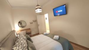 a bedroom with a bed and a tv on the wall at The PM - in the heart of Thessaloniki in Thessaloniki