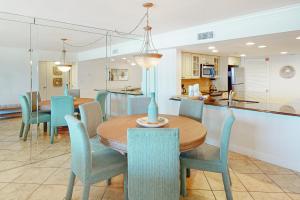 a dining room and kitchen with a table and chairs at Breakers East 604 in Destin