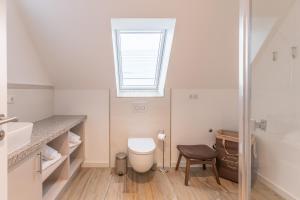 a bathroom with a toilet and a window at Getidenhus Moand in Sankt Peter-Ording