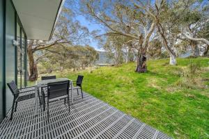 a patio with a table and chairs on a house at Ecocrackenback 9 Sustainable chalet close to the slopes in Crackenback