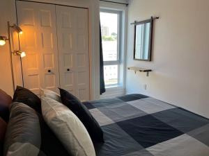 a bedroom with a bed and a window and a door at Joli condo en basse-ville - Parking gratuit 309357 in Quebec City