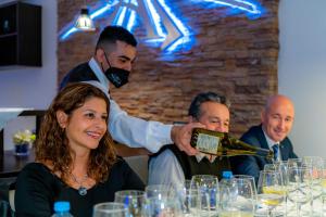 a man pouring a bottle of wine for a woman at Hotel Alto Verde in Termas de Río Hondo