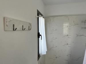 ducha con puerta de cristal y toalla blanca en Villa General Belgrano, sobre Lago Los Molinos in 