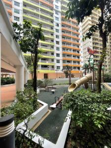 ein Park mit Spielplatz in einer Stadt mit hohen Gebäuden in der Unterkunft Dalamanda 3Pax Sunway Velocity Balcony CItyView in Kuala Lumpur