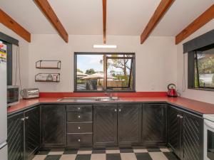 a kitchen with a sink and a window at Surfscape - Whitianga Holiday Home in Whitianga