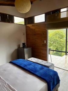 a bedroom with a bed and a large window at Glamping Bellavista in La Vega