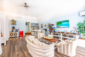 a living room with white chairs and a table at Palms Cottage at Viking Hill in Nassau