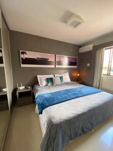 a bedroom with a large bed with blue sheets at Flat Decoração Náutica c/Vista Lago Paranoá in Brasilia